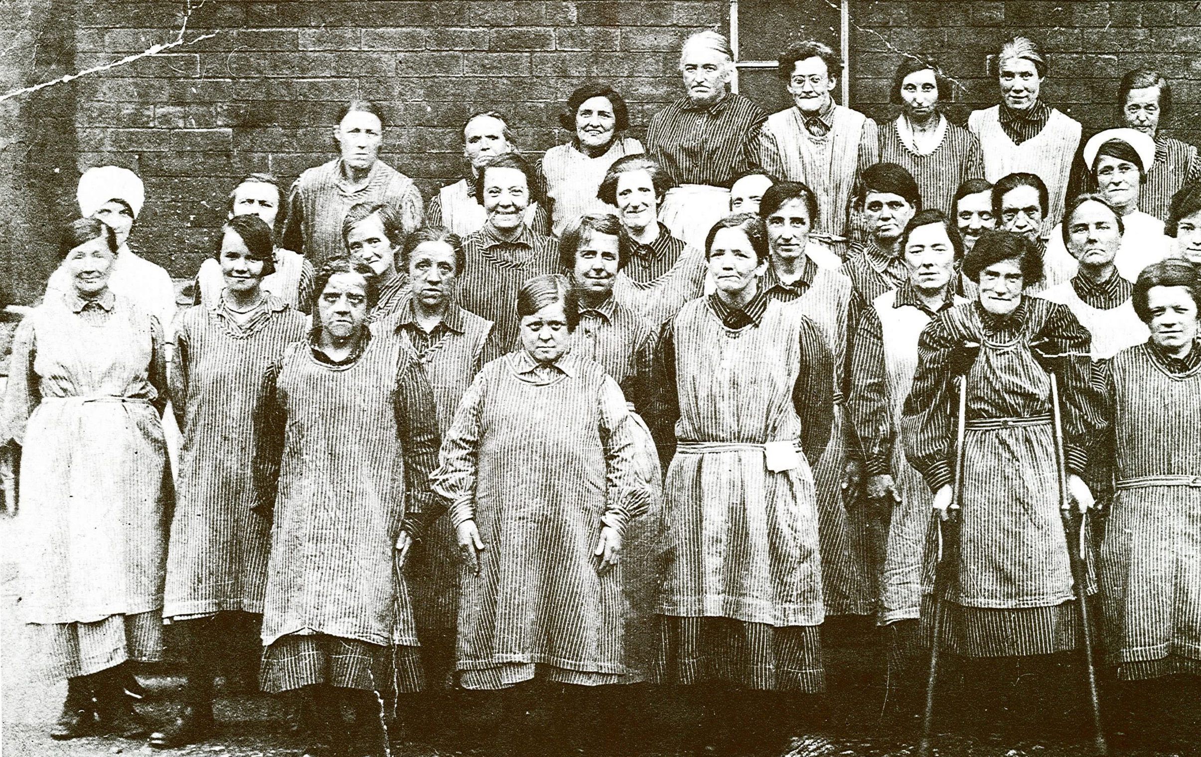 a group of women in victorian workhouse uniform